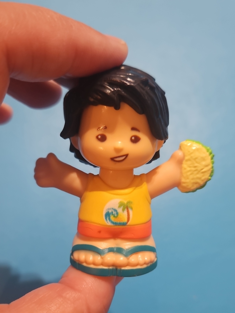 Fisher-Price Little People figure, specifically Koby, holding a taco